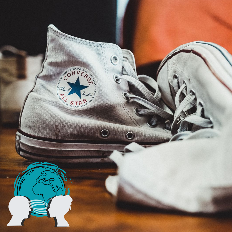 A color image of a pair of converse sneakers and an icon of two silhouettes considering things from each other's perspectives. The image provides and introduction to Cultured Kids focus on empathy in the Art & Storytelling Book Club Program.  